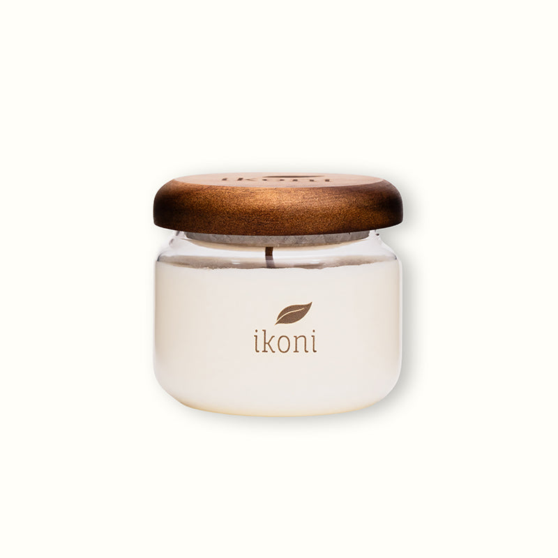 Glass jar with wooden lid that is ikoni Premium Candle.