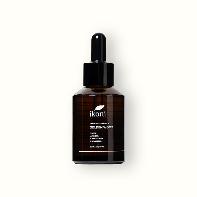 A brown glass bottle with black dropper of ikoni Golden Womb body oil.