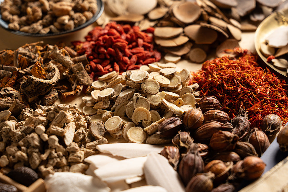 Assorted dried Chinese herbs and on a wooden surface.